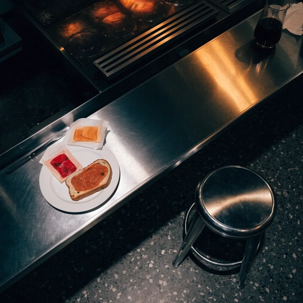 Blank paper order slips clipped on a stainless rail above a diner pass